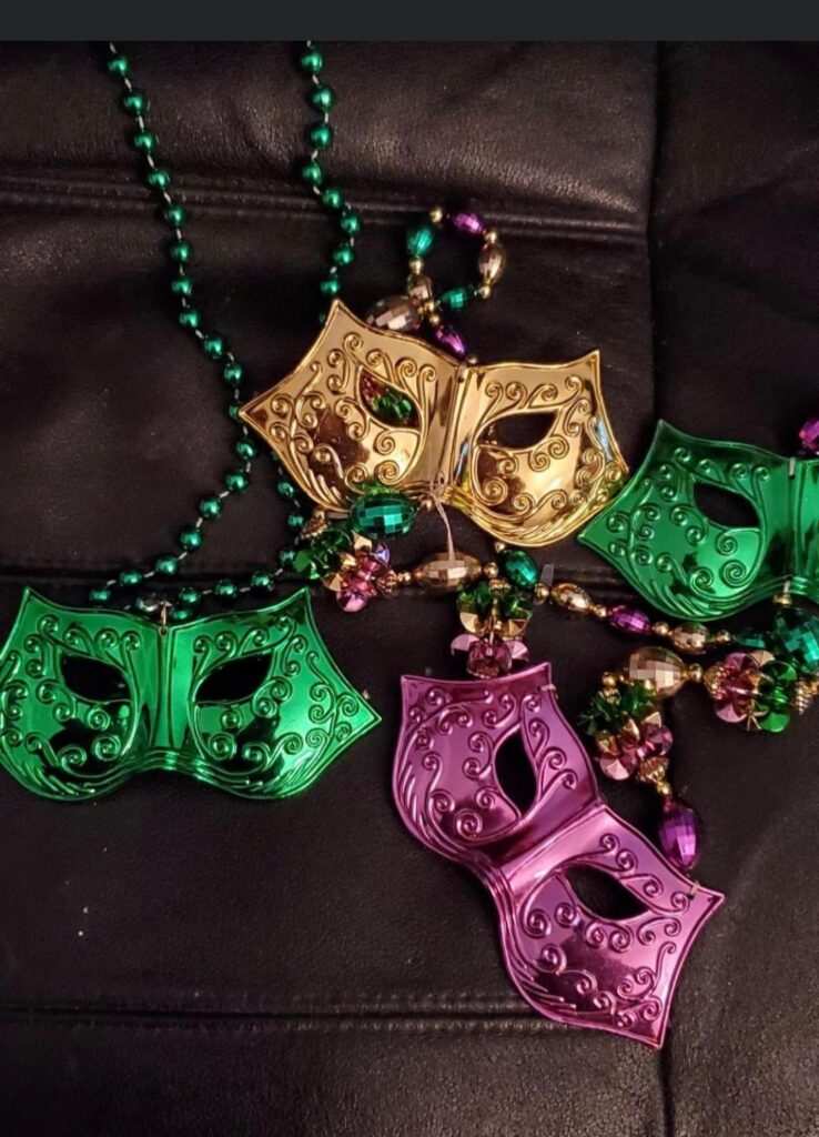Four masks on Mardi Gras beads
