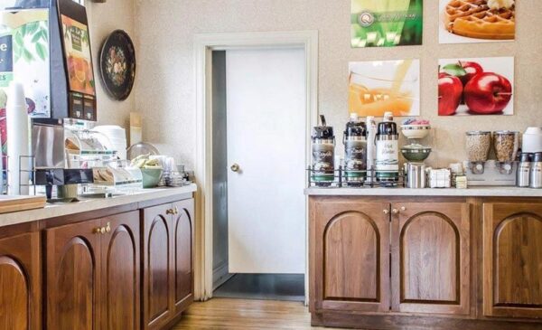 A coffee shop with wooden cabinets and pictures on the wall.